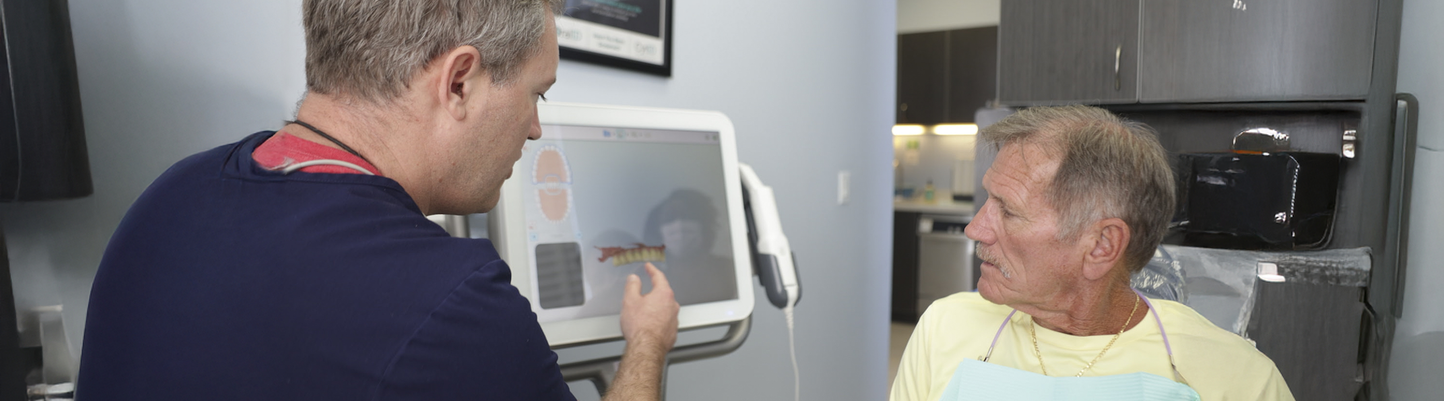 Dentist showing a senior man a digital scan of his teeth in Jupiter dental office