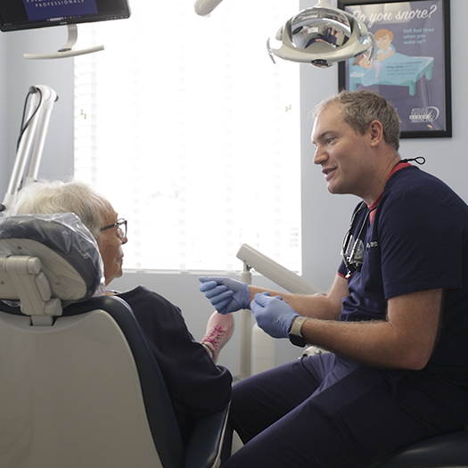 Dentist talking to a senior woman in the dental chair