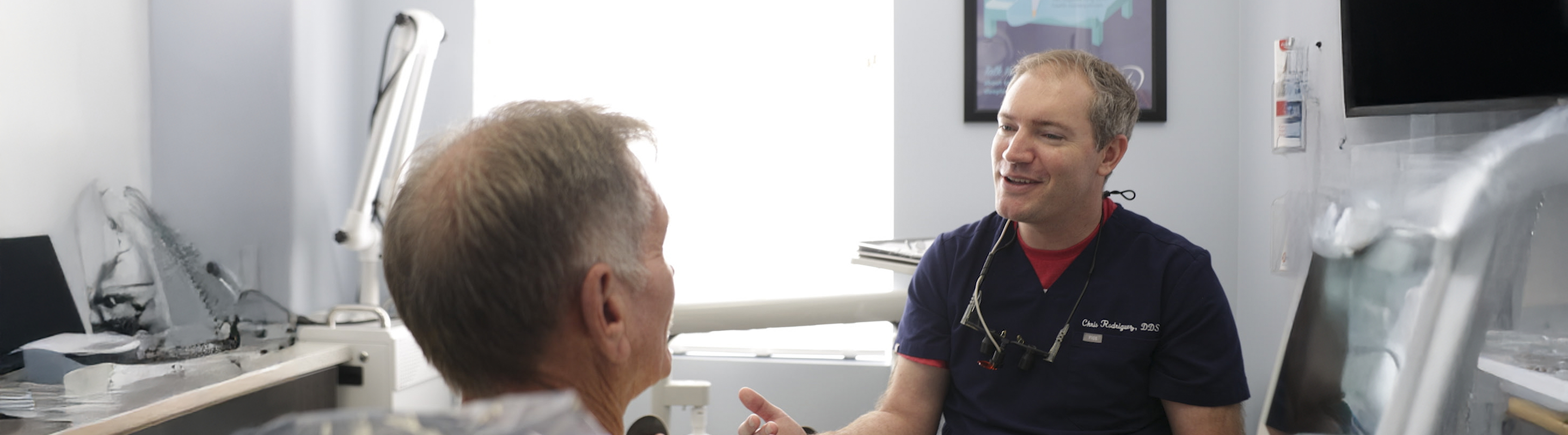 Senior man in dental chair talking to his dentist in Jupiter