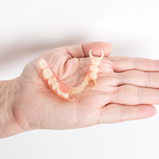 Hand holding a partial denture