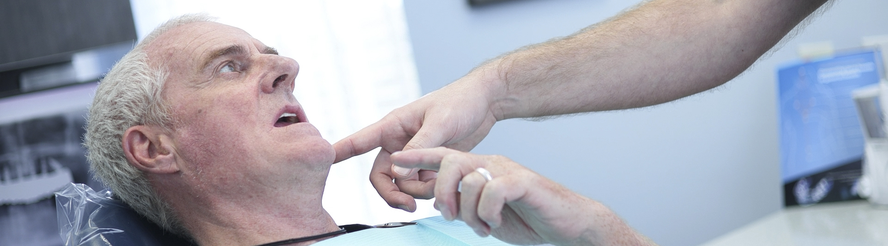 Dental patient pointing to his mouth