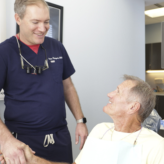 Smiling senior man shaking hands with his dentist