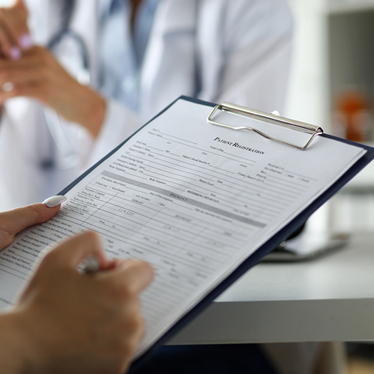 Person filling out paperwork on a clipboard