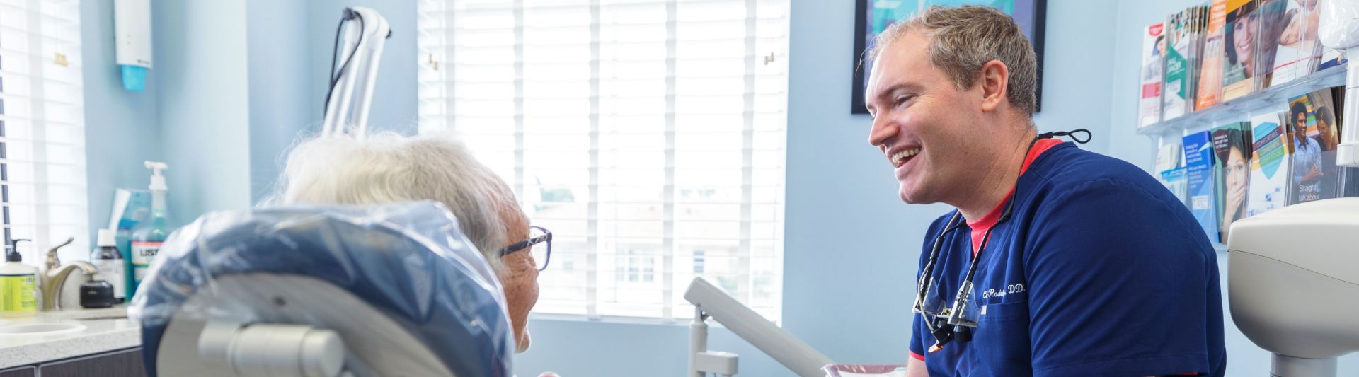 Dentist talking to a senior patient about dentures and dental implants in Jupiter