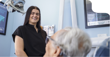 Dental team member smiling at a patient in the treatment chair