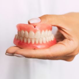 Dentist holding a set of full dentures