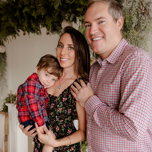 Doctor Rodriguez smiling with his wife and young child