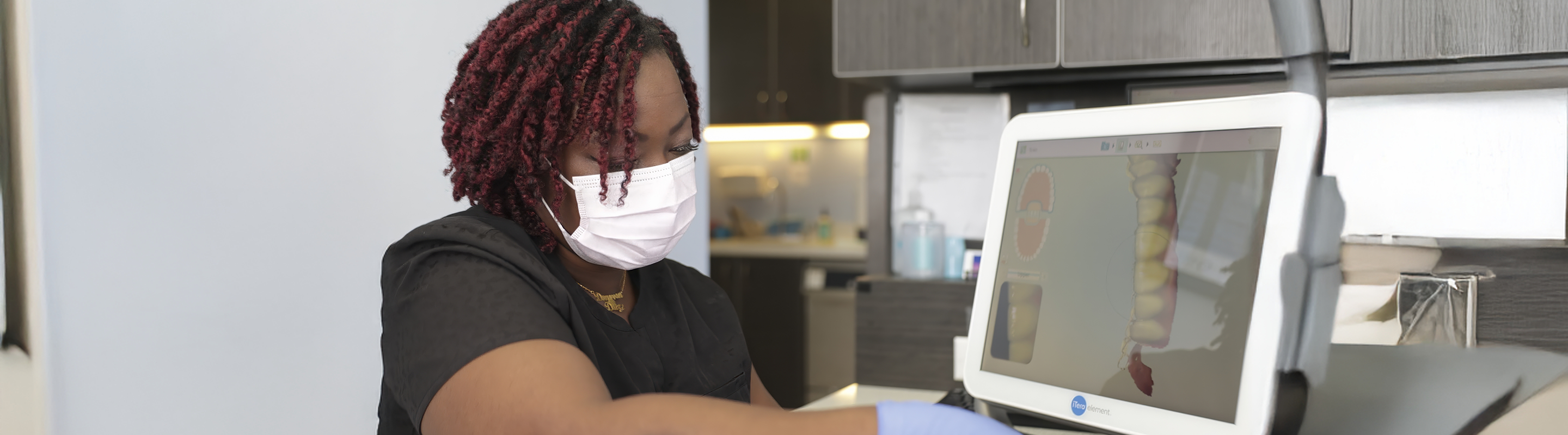 Jupiter dental team member next to a monitor showing digital impressions of teeth